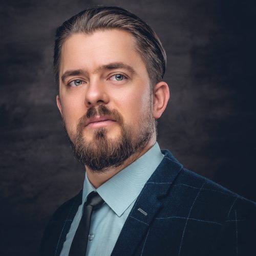 Portrait of an elegant bearded man dressed in a wool jacket and bow tie.